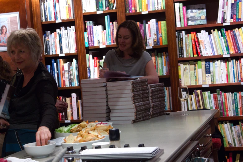 two women are sitting at a table in the liry