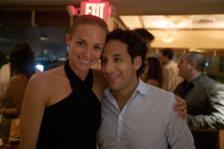 a man and woman in a bar posing for the camera