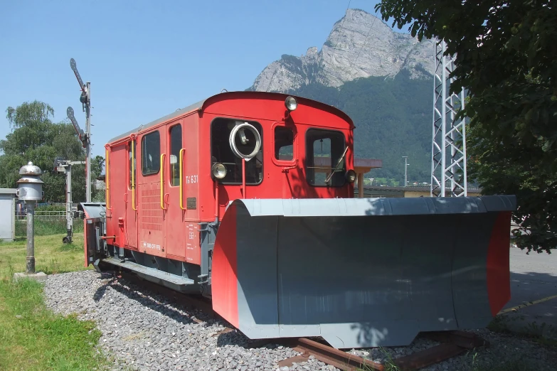 a red train engine sitting on top of the tracks