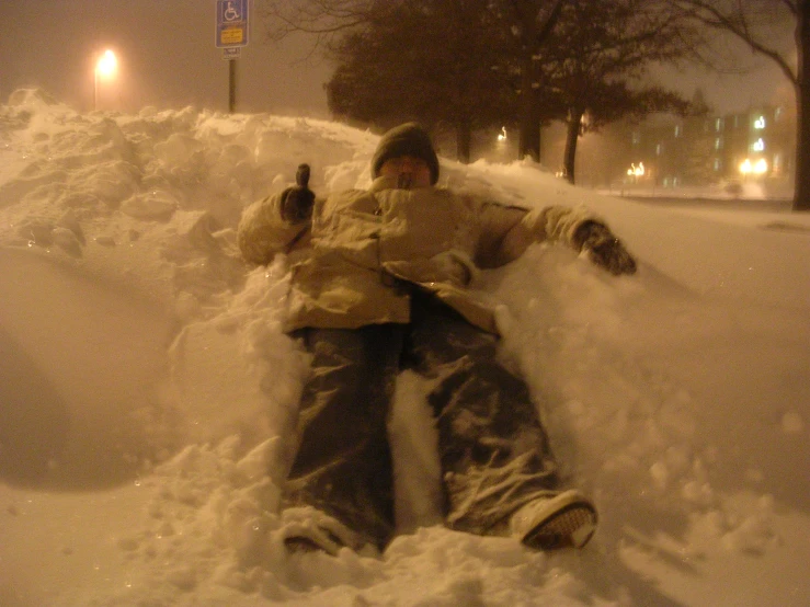 snowboarder resting in the middle of the pile of snow on a street