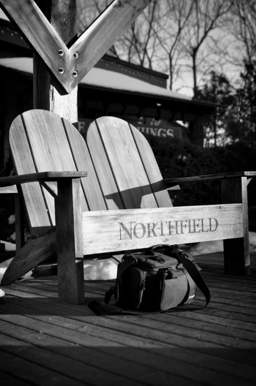 a pair of wooden lawn chairs that have the name northfield written on it