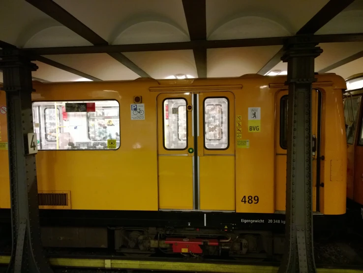 an old yellow train is parked under the covered train car
