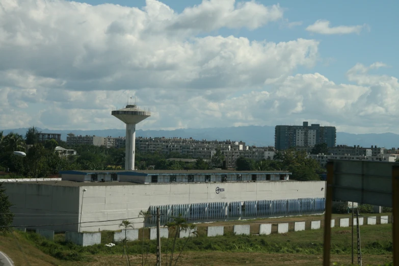 a very tall tower in the background of buildings and a field