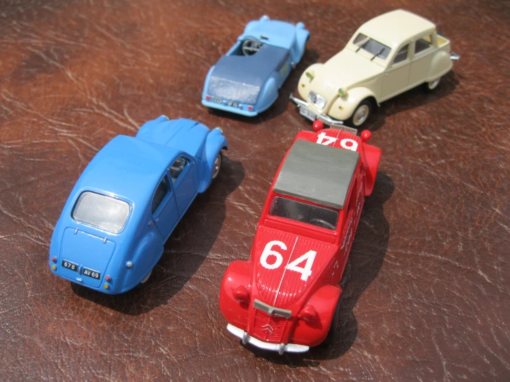 four toy cars that are on the ground