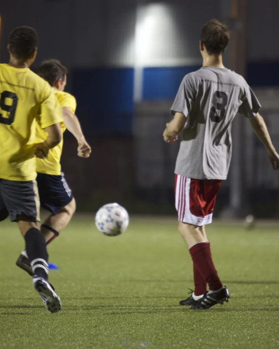 men playing soccer on a soccer field at night