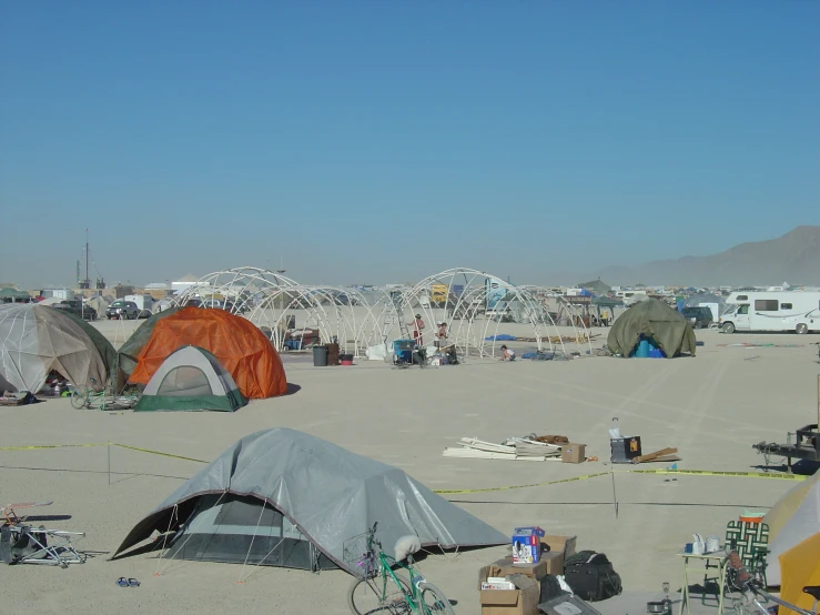 many tents on a sandy beach near the ocean