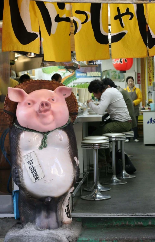 a pig statue is in front of a restaurant