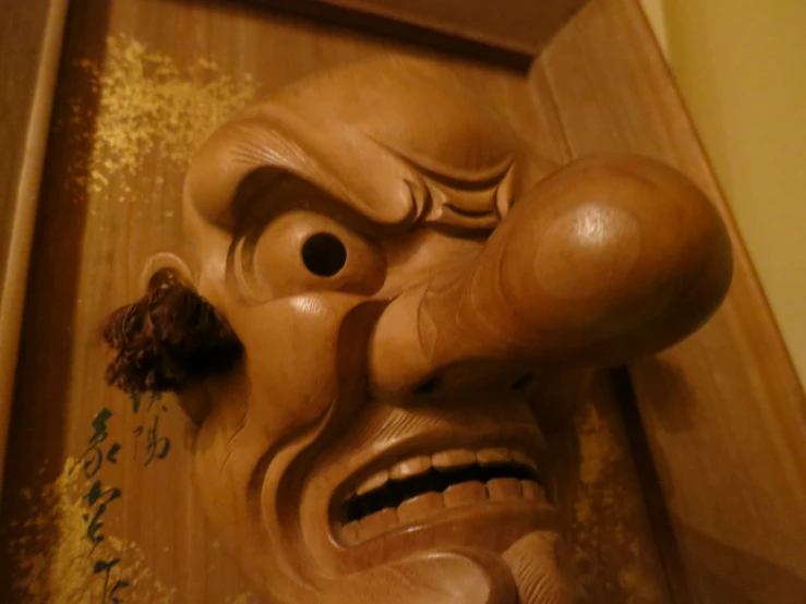 a brown mask on top of a wooden shelf