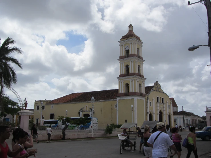 people are walking around a street with a large church in the background