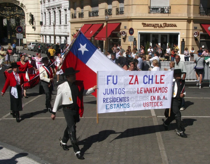 people dressed in spanish and american clothes marching down the street