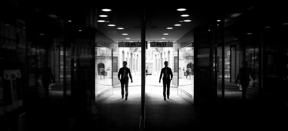 two people walking in the dark outside a building