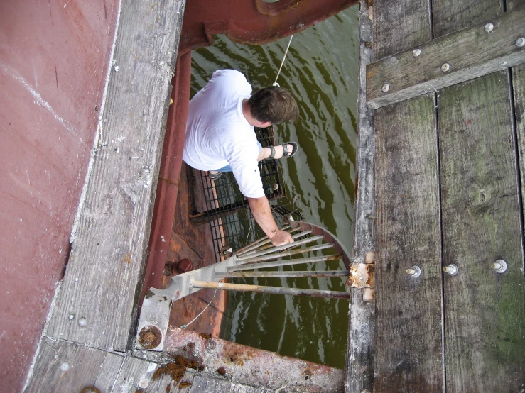 man looking at water with metal structure above