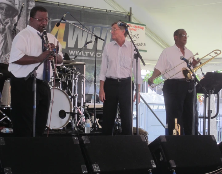 an image of three men on stage with instruments