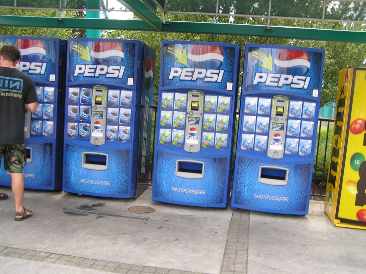 a row of soda machines sitting on a sidewalk