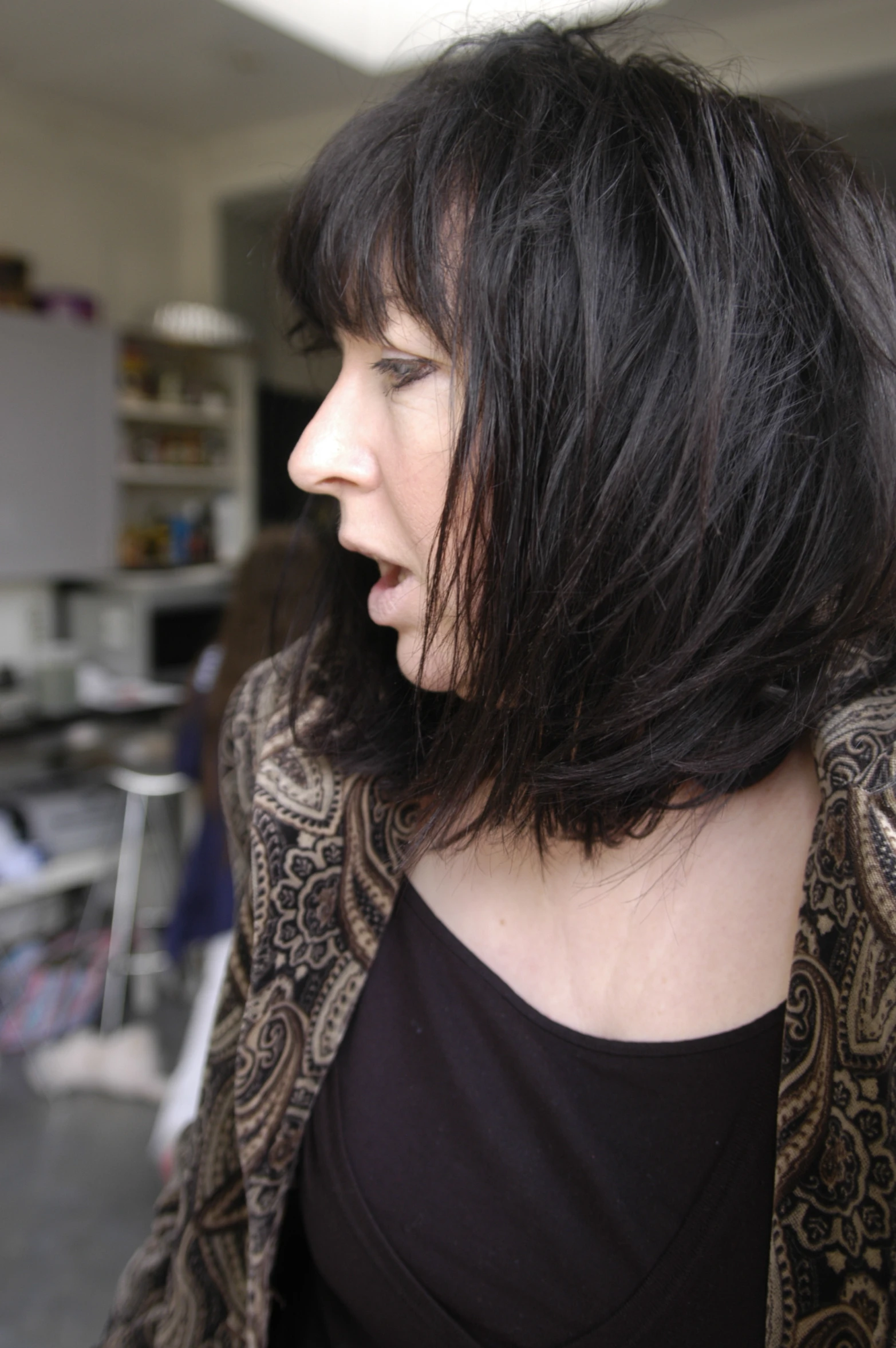 a woman with long black hair is staring away