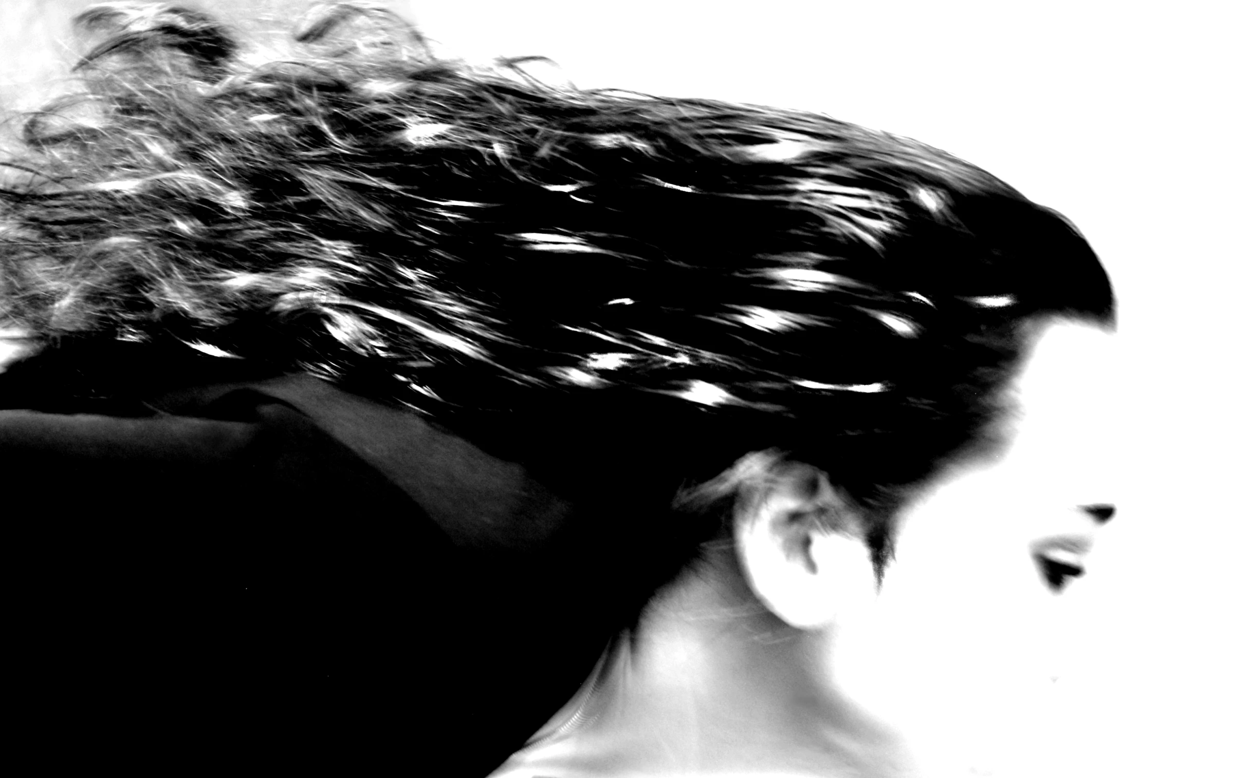 the back of a person's head is shown with very long wavy hair