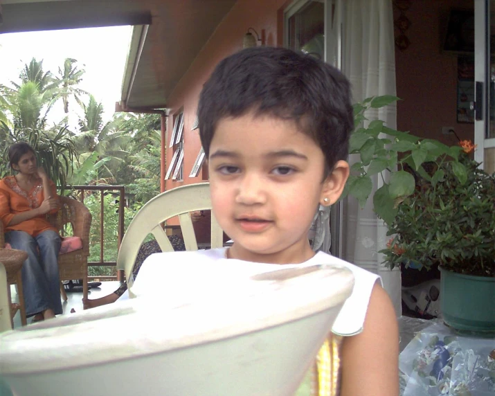 a girl is holding up a white bowl