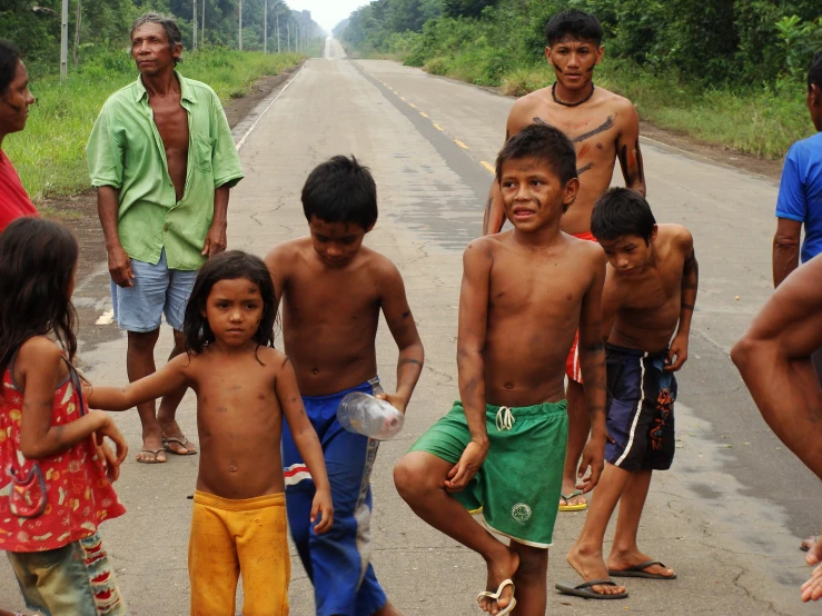 a group of s standing around on a road