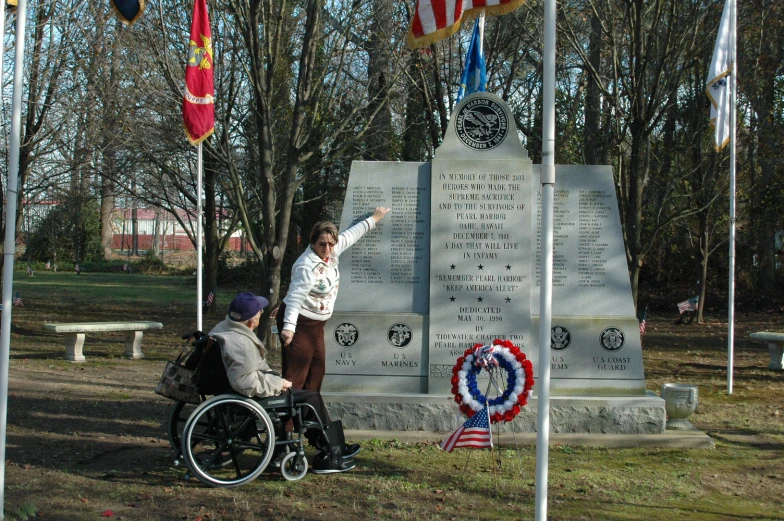 the man in his wheelchair is pointing to the flag