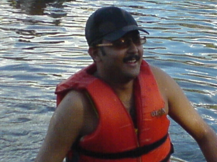 a man that is standing in some water with a vest on