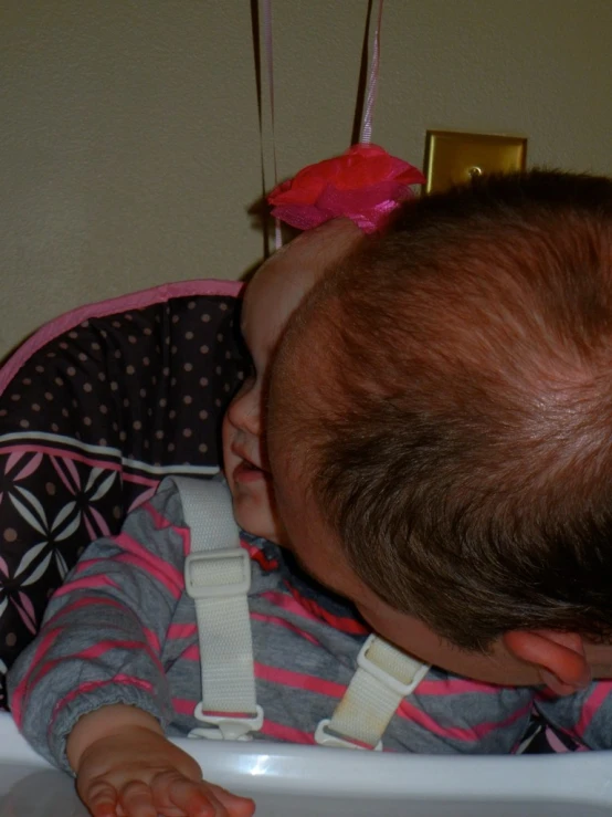 a small baby standing inside of a high chair