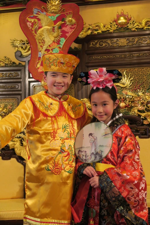 young children in traditional asian clothing posing for a picture