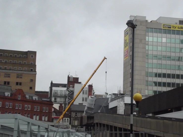 a crane hanging over a city filled with tall buildings