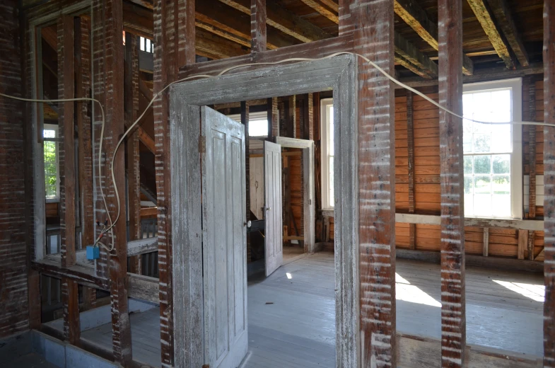 an open door on a wall with wooden framed windows