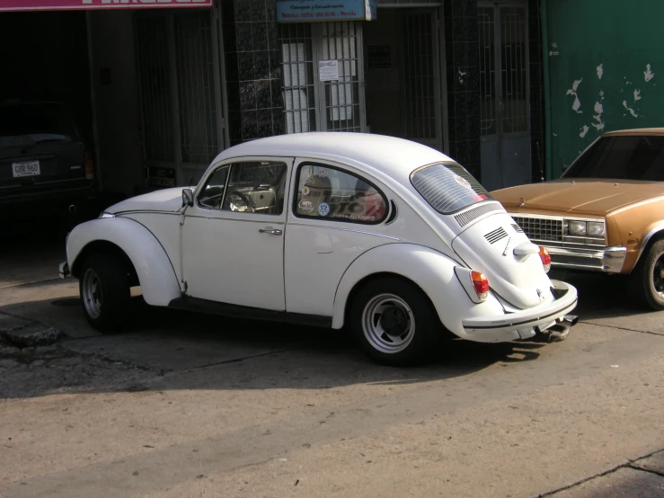 two different color cars parked side by side on a street