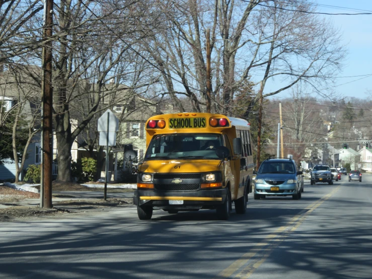 a school bus is coming up a residential street