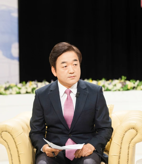 a man sits in a chair reading soing