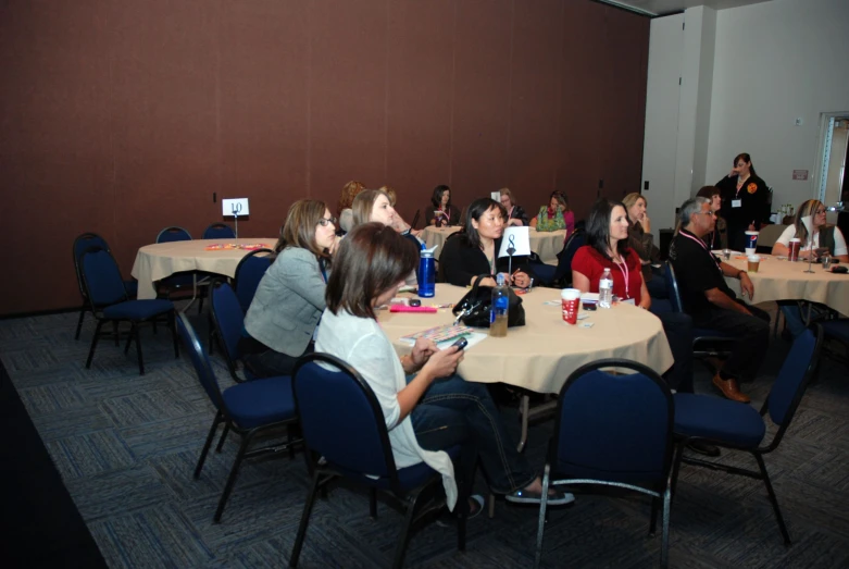 people sitting at a round table listening to some speakers