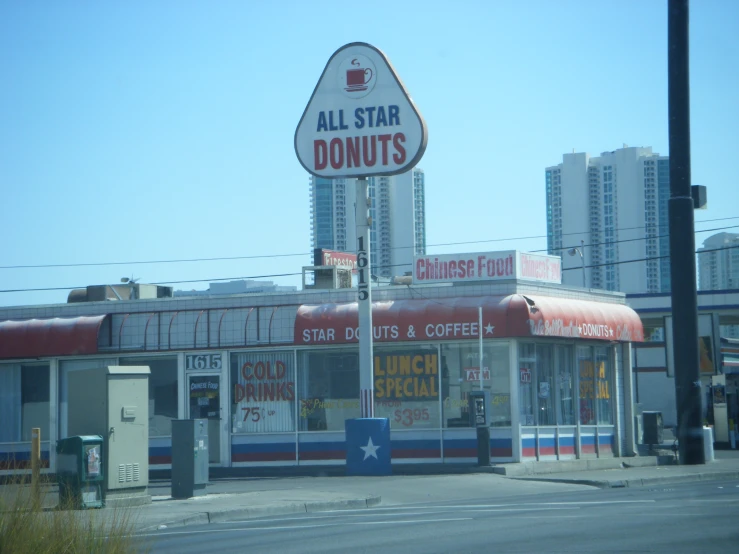 a street sign that says all star donuts next to a doughnut shop