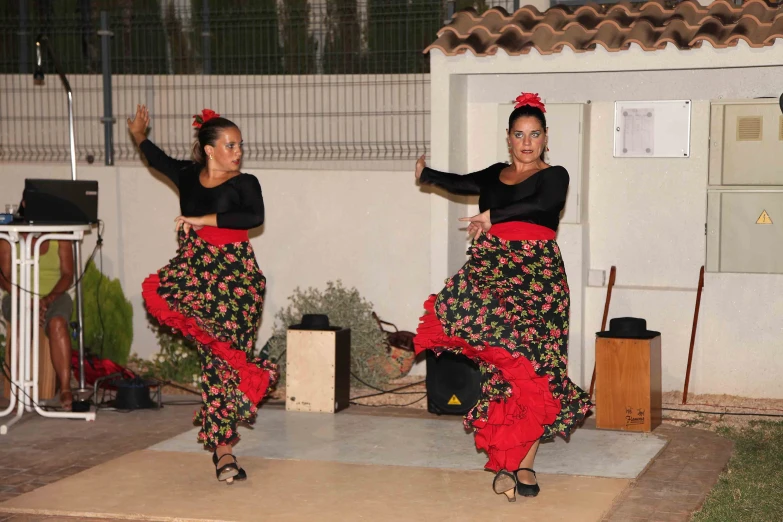two women with red skirts are dancing