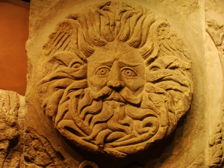 an image of a carved stone face in a museum setting
