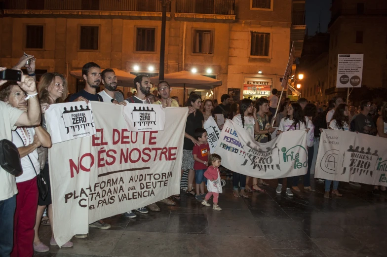 people stand holding signs as they take part in an anti - racism march