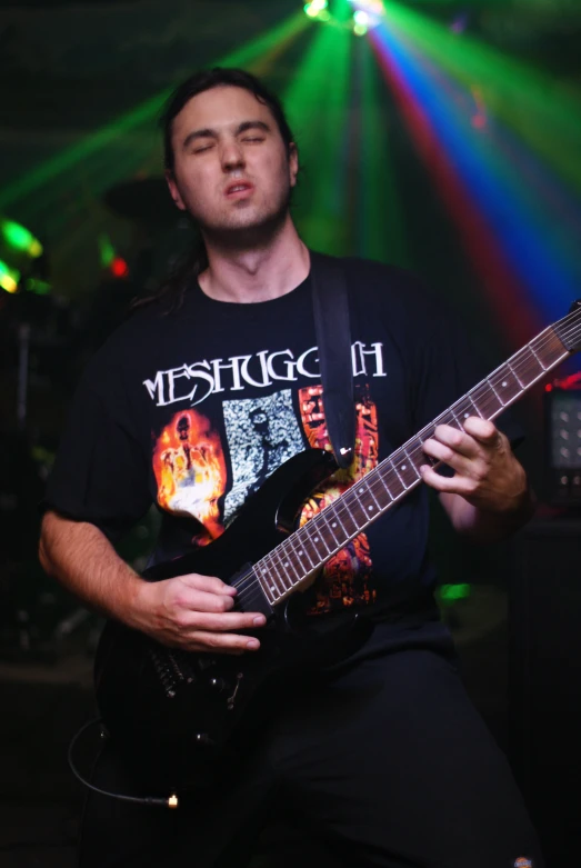 a guy that is playing a guitar in front of some lights