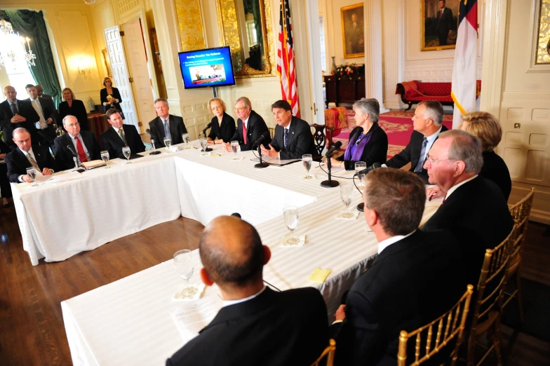 a group of people sitting around a long table