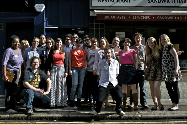 there are many people standing together in front of the restaurant