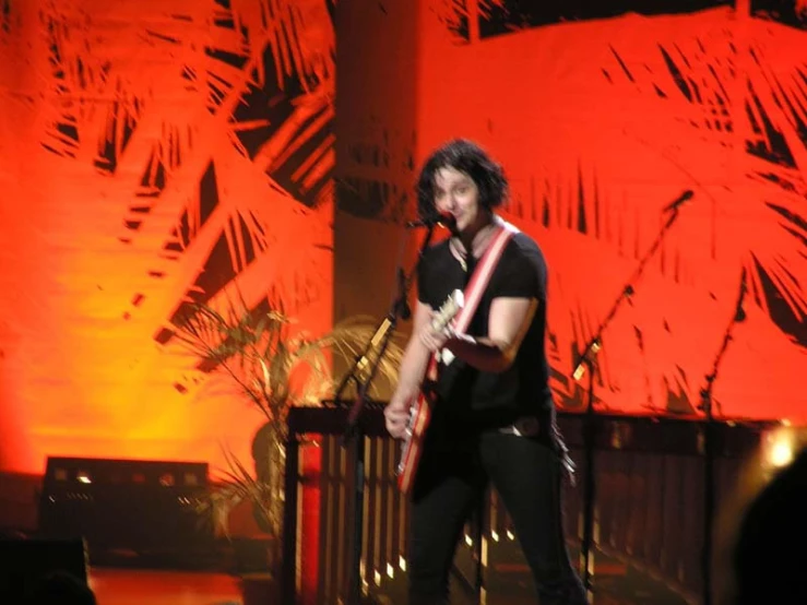 a man with a microphone is playing guitar
