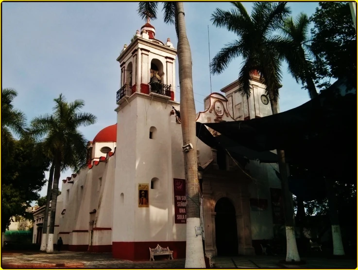 large clock tower in front of palm trees