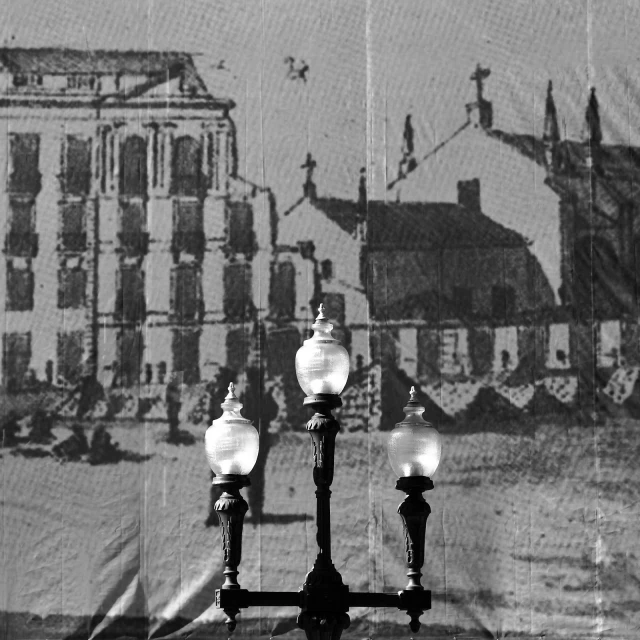 a black and white po of a street light with people walking past it