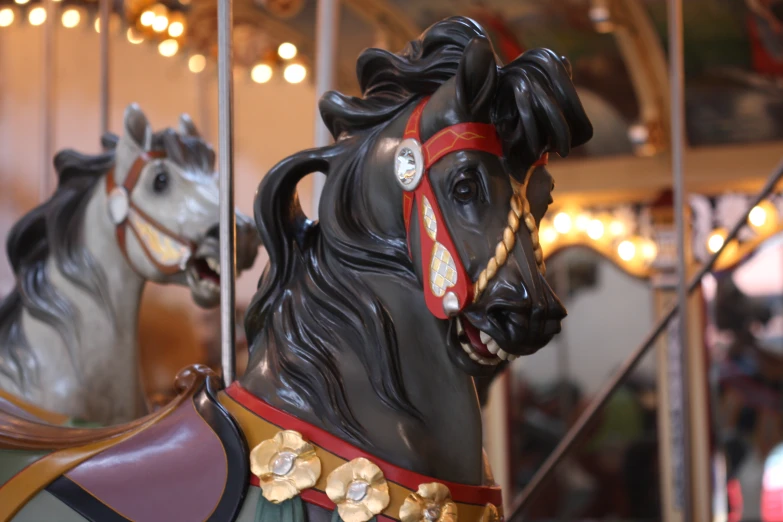 a couple of fancy carousel horses riding on a merry go round