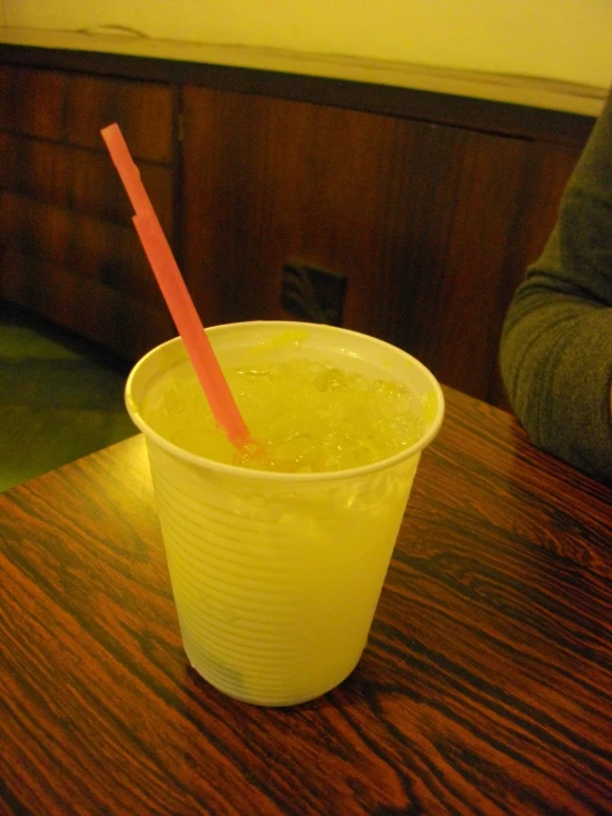 a cup full of drink sitting on top of a wooden table