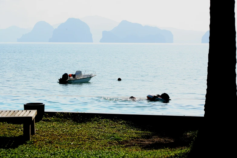 some people swimming and a boat in the ocean