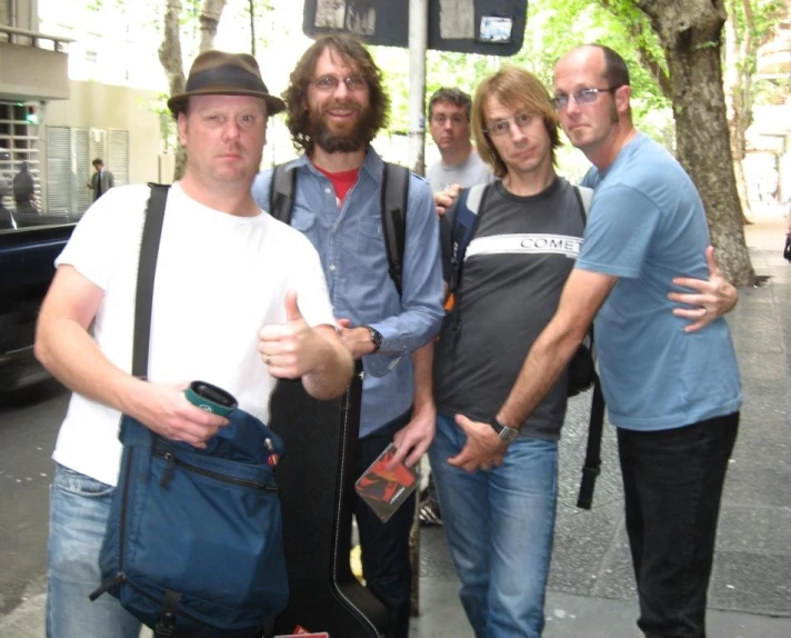 a group of people are standing in front of a bus