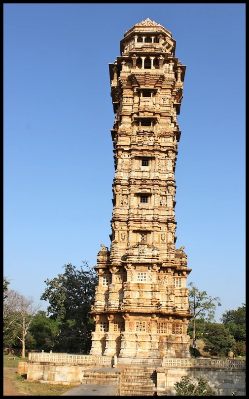 a clock tower made out of bricks sitting near the trees