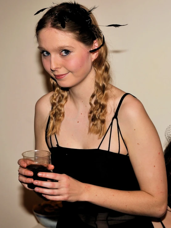 a young woman holding a drink in her hands