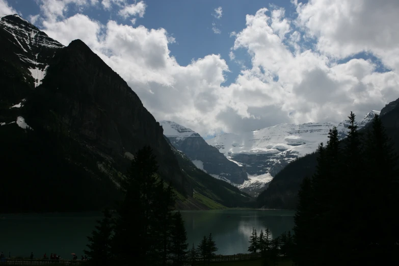 the trees are along a lake in the mountains