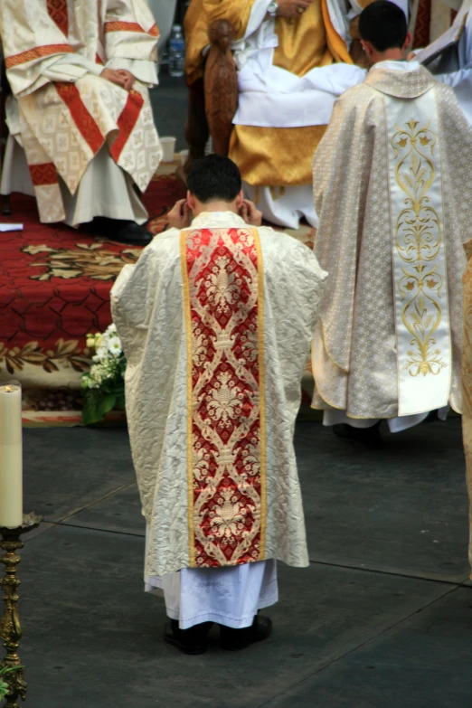 priests are walking in front of a large crowd